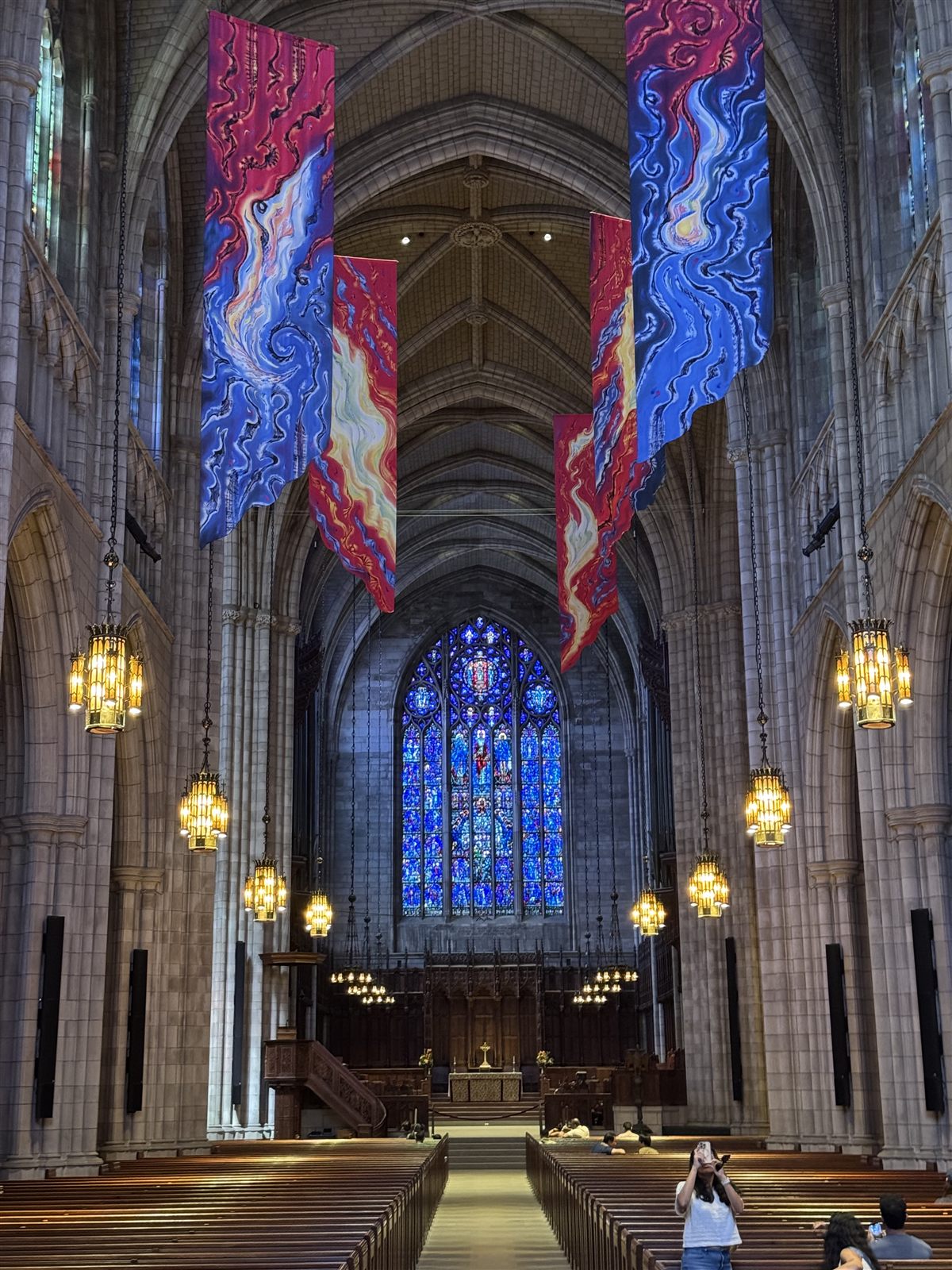 Cathedral nave with hanging banners and stained glass