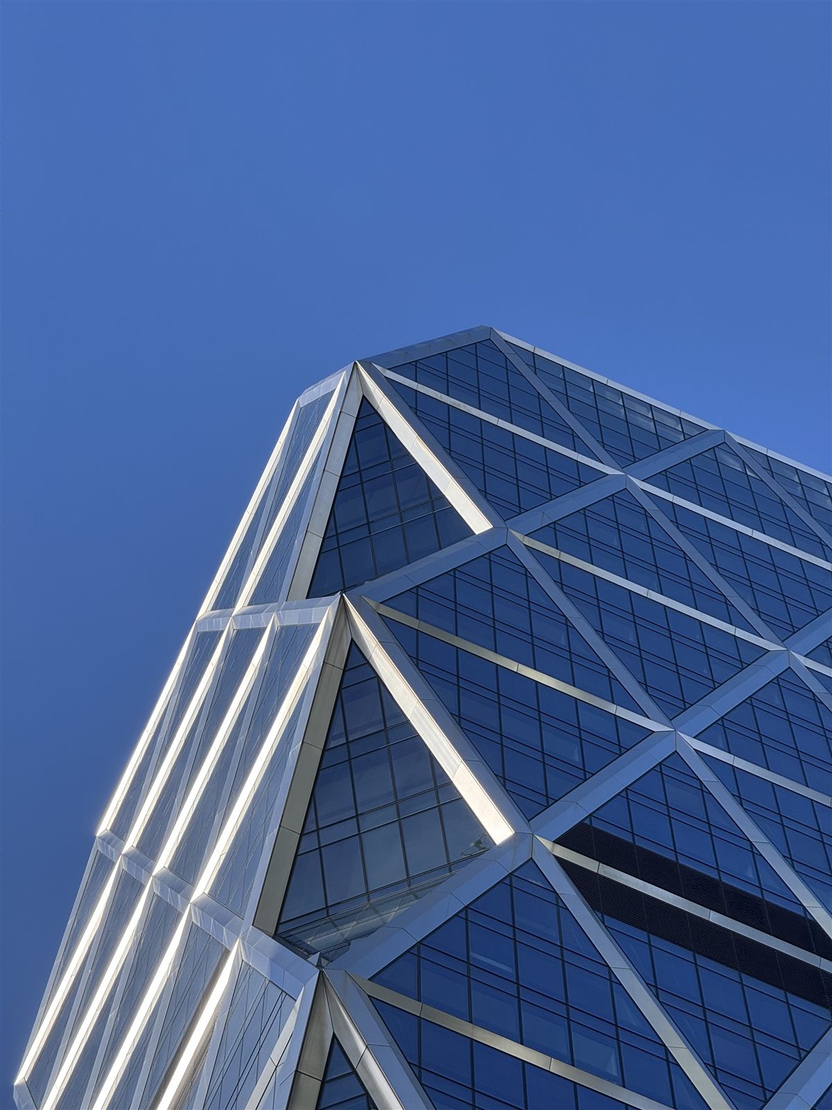 Diagrid glass facade of Hearst Tower against a blue sky