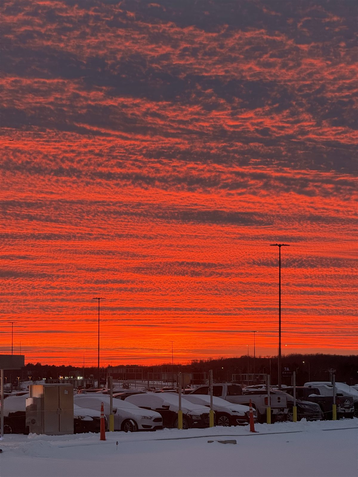 Bright orange sunset over a snowy parking lot